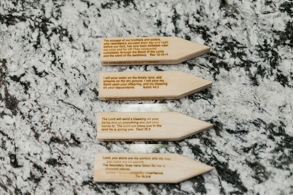 Engraved wooden stakes with Scripture — Revelation 12, Isaiah 44:3, Deuteronomy 28:8